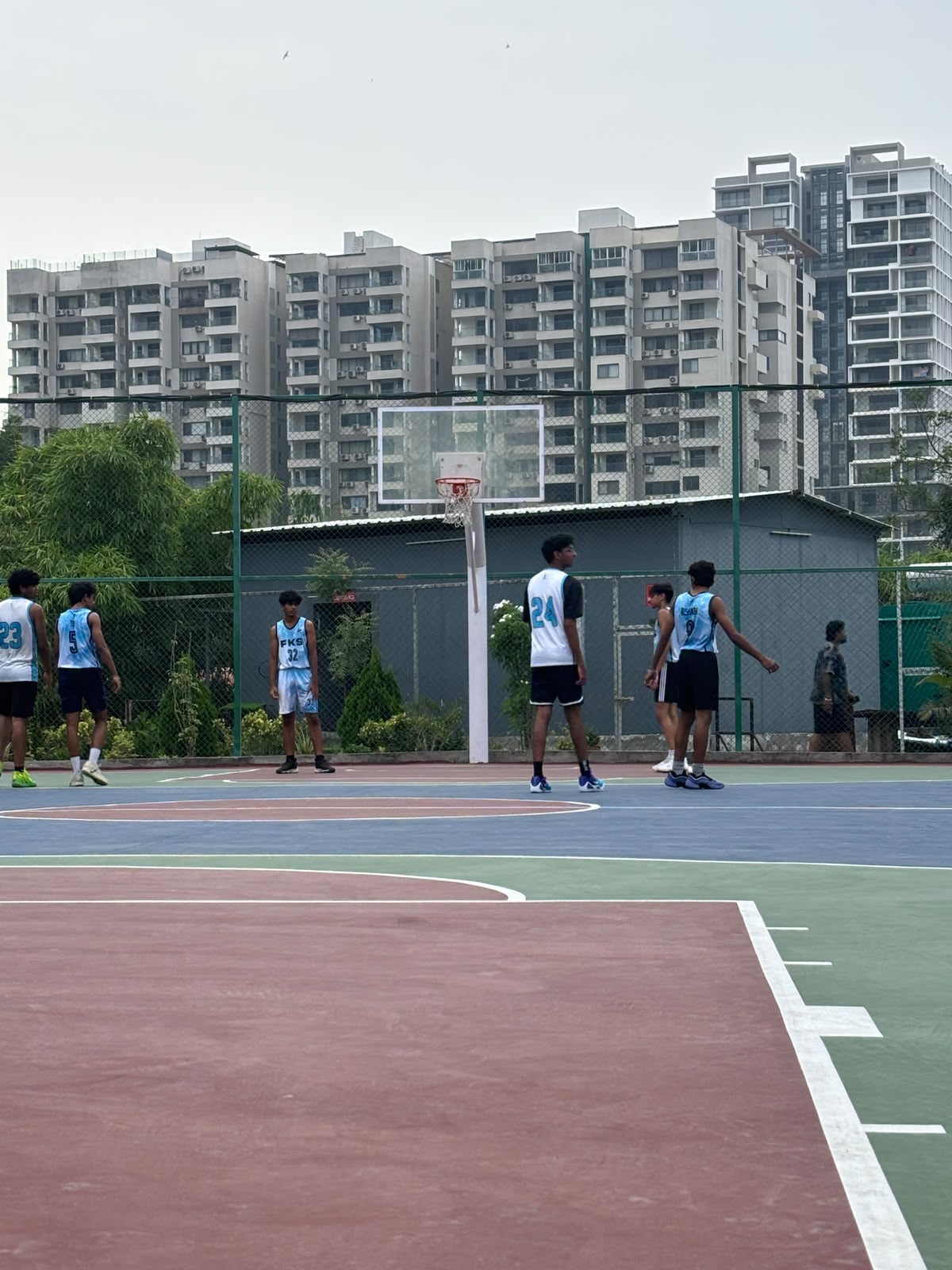 Players on an outdoor basketball court during a varsity game
