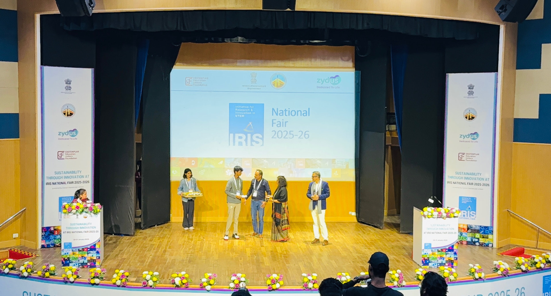 Raksheet Gummakonda receiving an award on stage at the IRIS National Fair 2025-26